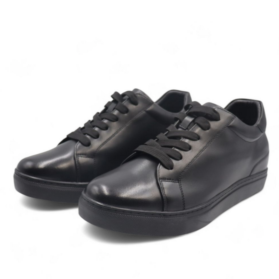 Pair of black leather sneakers on a white background